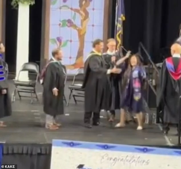 Kansas high school administrator forcibly shakes hands with celebrating graduates